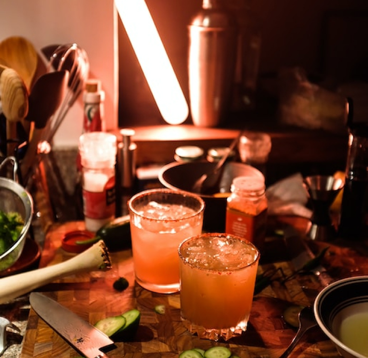 cocktails in short glasses with cayan pepper, on a chopping board with cucumber